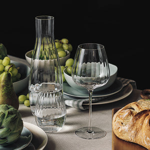Hadeland Glassverk Prestige vannglass sammen med en karaffel og vinglass på et elegant dekket bord med frukt og brød.