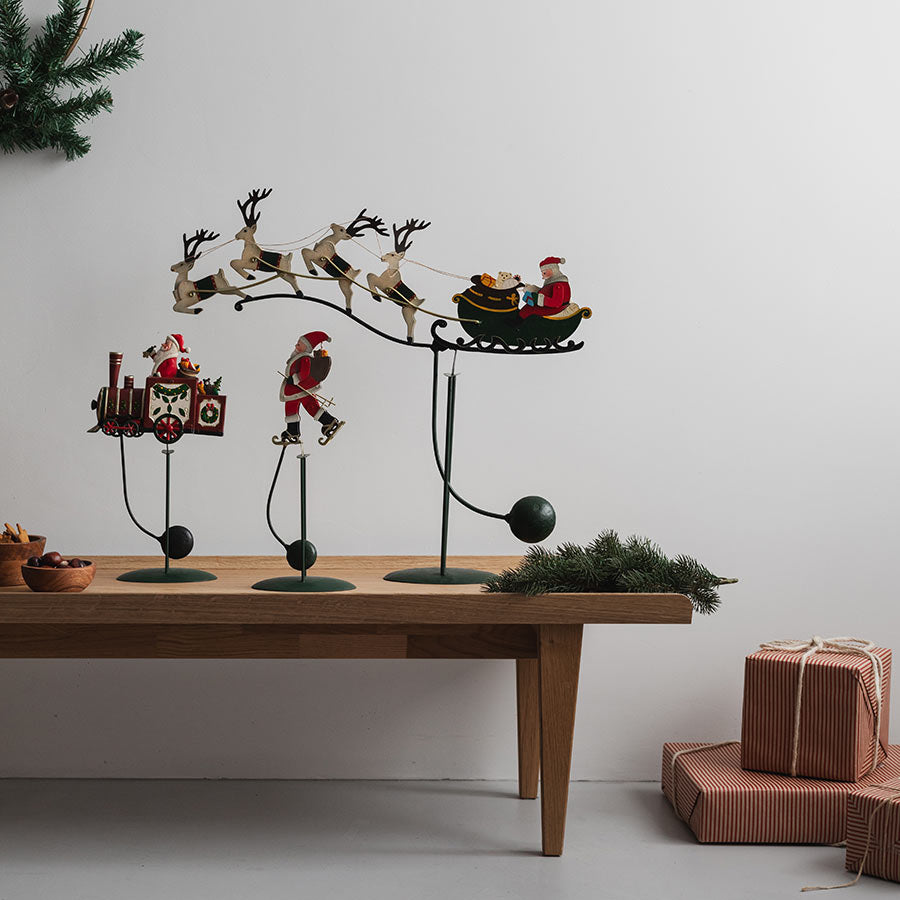 Julekolleksjon fra CHRISTIANIA 1739: Tre deler med Gyngende Nissefar, reinsdyr og slede på en stilren borddekorasjon.