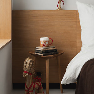 Christiania 1739 julekrus formet som et pepperkakehus, plassert på en trebord ved siden av bøker og dekorasjoner.