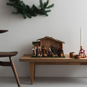 Christiania 1739 Julekolleksjon Julekrybbe med stall og 10 figurer, placert på et stilrent bord med juledekor, som skaper julestemning i rommet.