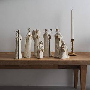 Christiania 1739 Julekolleksjon Julekrybbe Sett 7 Deler Hvit: utvalg av hvite julekrybbefigurer vises i en stilren innredning med lys og blomster.
