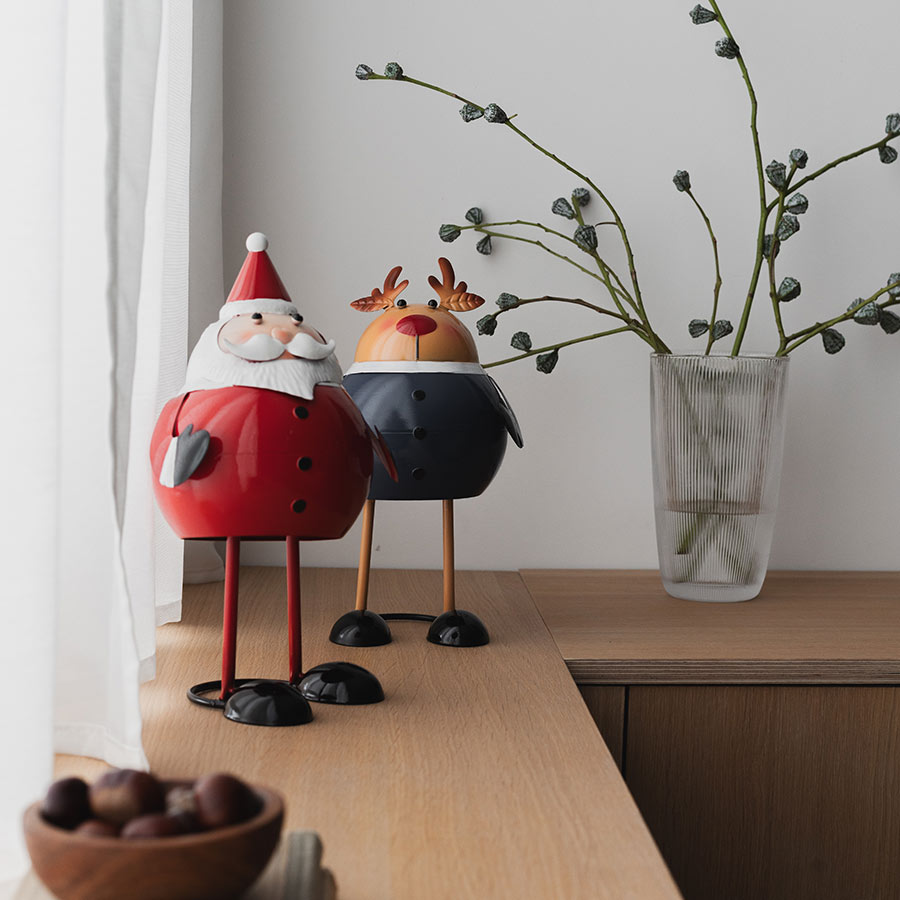 Christiania 1739 Julekolleksjon Figur Reinsdyr 18cm, reinsdyrfigur sammen med en julenissefigur på et konsollbord, skaper en festlig atmosfære.