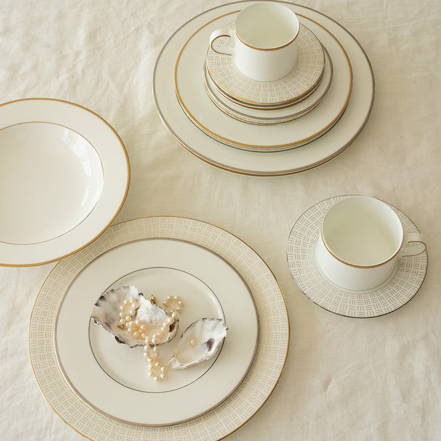 Flott borddekorasjon med Porsgrund Porselænsfabrik Vivienne Gull Tallerken 28cm og tilhørende servise. Bordet er dekket med stilige serveringsfat og kopper i eksklusivt benporselen.