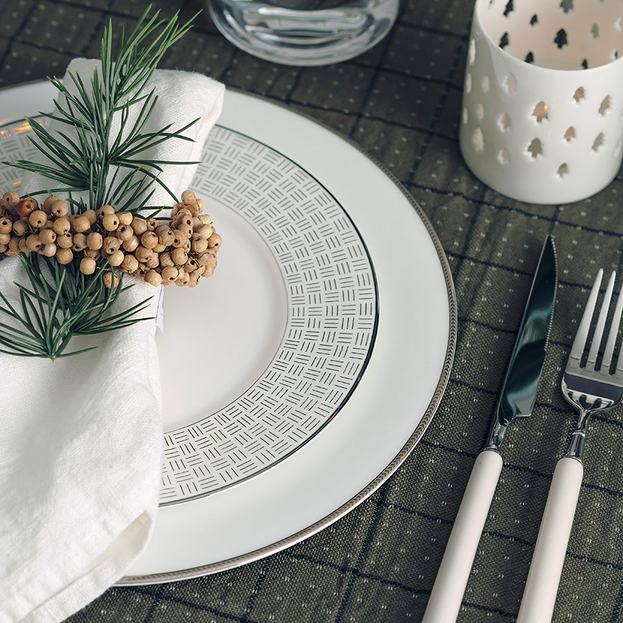 Porsgrund Porselænsfabrik Vivienne Gull Tallerken 22cm dekorerer et elegant bord med serviet og bestikk, perfekt for festlige anledninger.