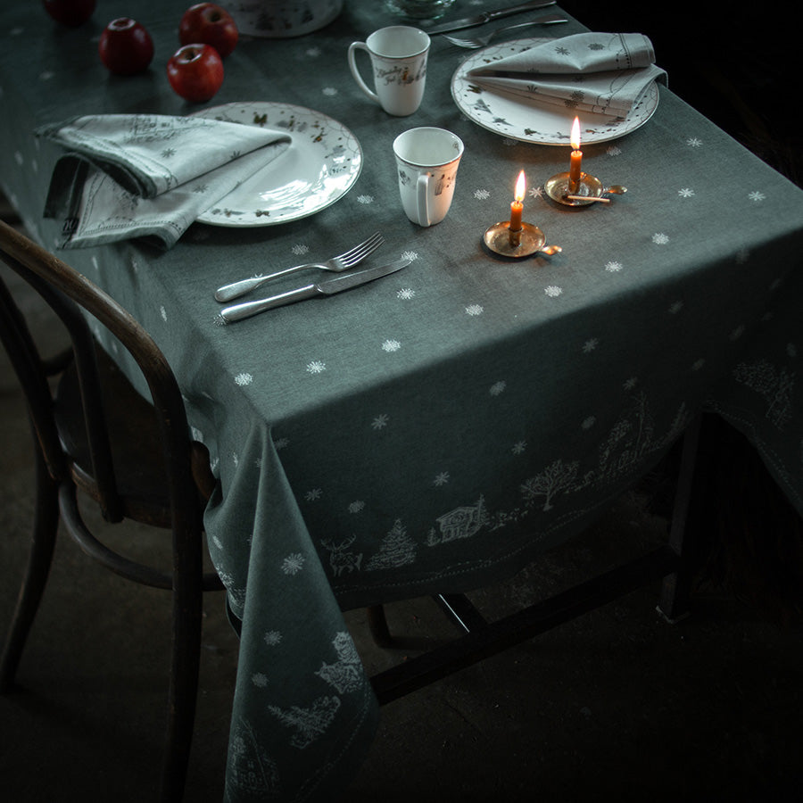 Stilfullt dekorerte julebord med Wik & Walsøe damaskduk i grønn, som fremhever elegant bordsetting.