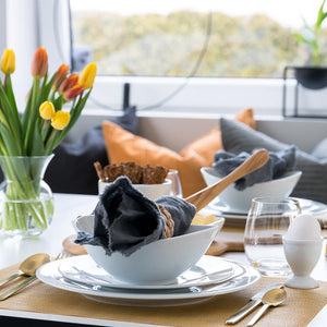 Porsgrunds Porselænsfabrik Sense Eggeglass 4 pk Hvit, stilfullt dekket bord med hvitt eggeglass, servise og blomsterdekore.