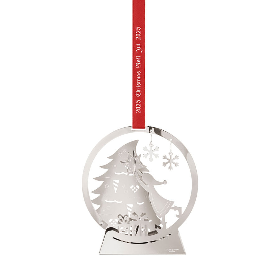 Georg Jensen juleuro 2025 med palladiumbelagt design, som viser en liten jente som plasserer stjernen på toppen av et juletre, med et rødt bånd for oppheng. Perfekt julepynt for å skape julestemning.
