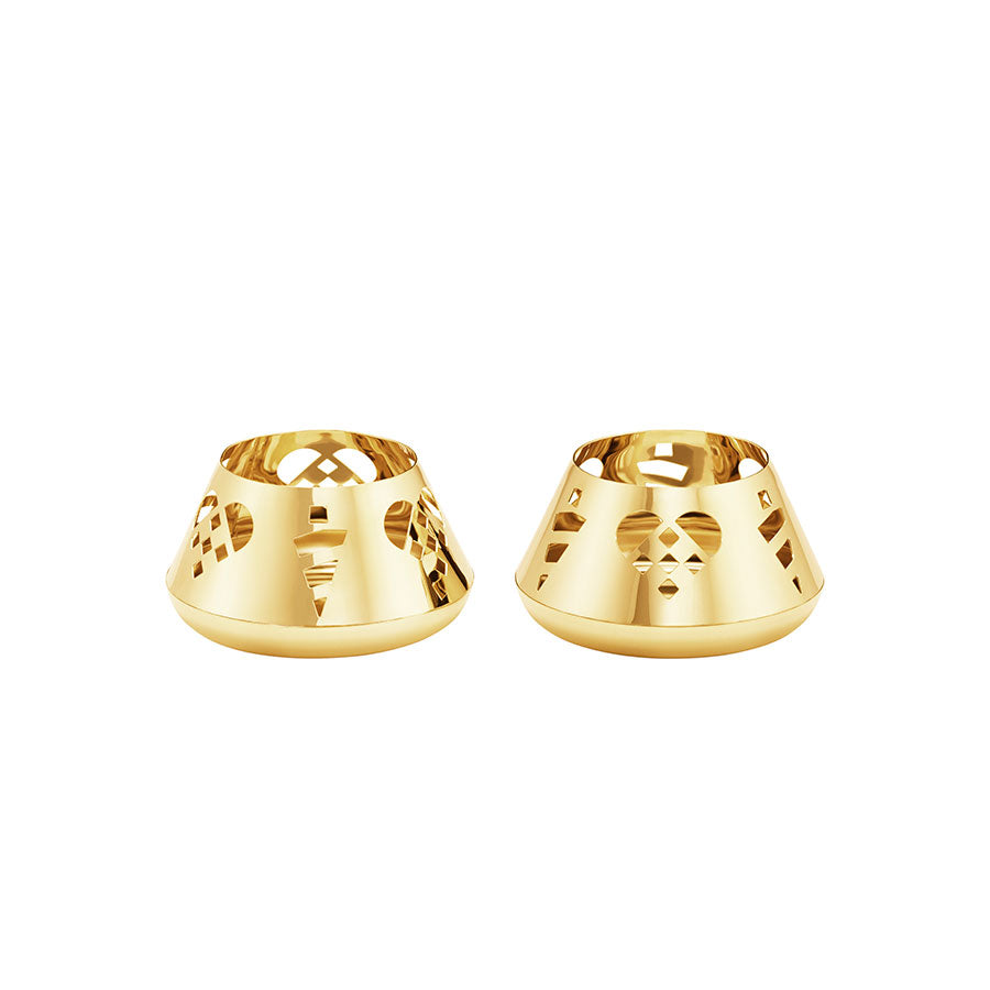 Elegante telysholdere fra Georg Jensen, i 18 karat gullbelagt stål, med utskårne julemotiver, perfekt for å skape en koselig julestemning.