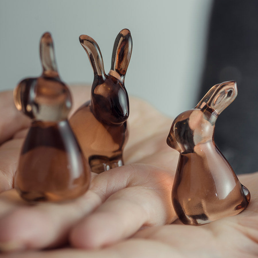 Tre små glassharer som holdes i en hånd, som viser detaljer av designet.