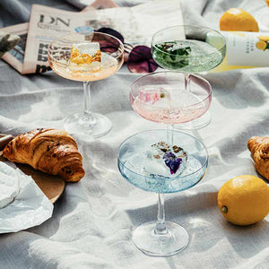 Hadeland Glassverk Odyssé Cavaskål Blå 25cl 2pk - variasjon av fargerike drinker servert i flere Odyssé glass, med bakgrunn av croissanter og sitron.