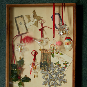 Holmegaard julepynt i glass, inkludert stjerner, fugler og hjerter, arrangert i en ramme med julekort, designet av Ann-Sofi Romme.
