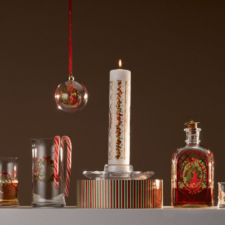 Holmegaard julekule for 2025, hengt sammen med julepynt og lys, illustrerer klassisk dansk design og skaper en varm julestemning.