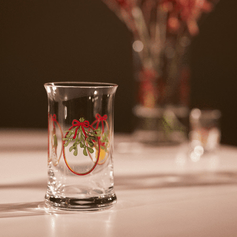 Holmegaard julevannglass med detaljerte julemotiver, skaper en varm atmosfære på bordet.