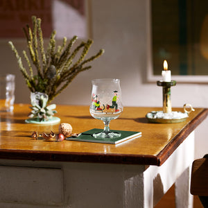 Holmegaard ølglass på et bord med julemotiver, perfekt til høytider og samlinger.