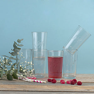 Norgesglasset drikkeglass 400ml med glassene stablet, omgitt av naturlige dekorasjoner og bær.