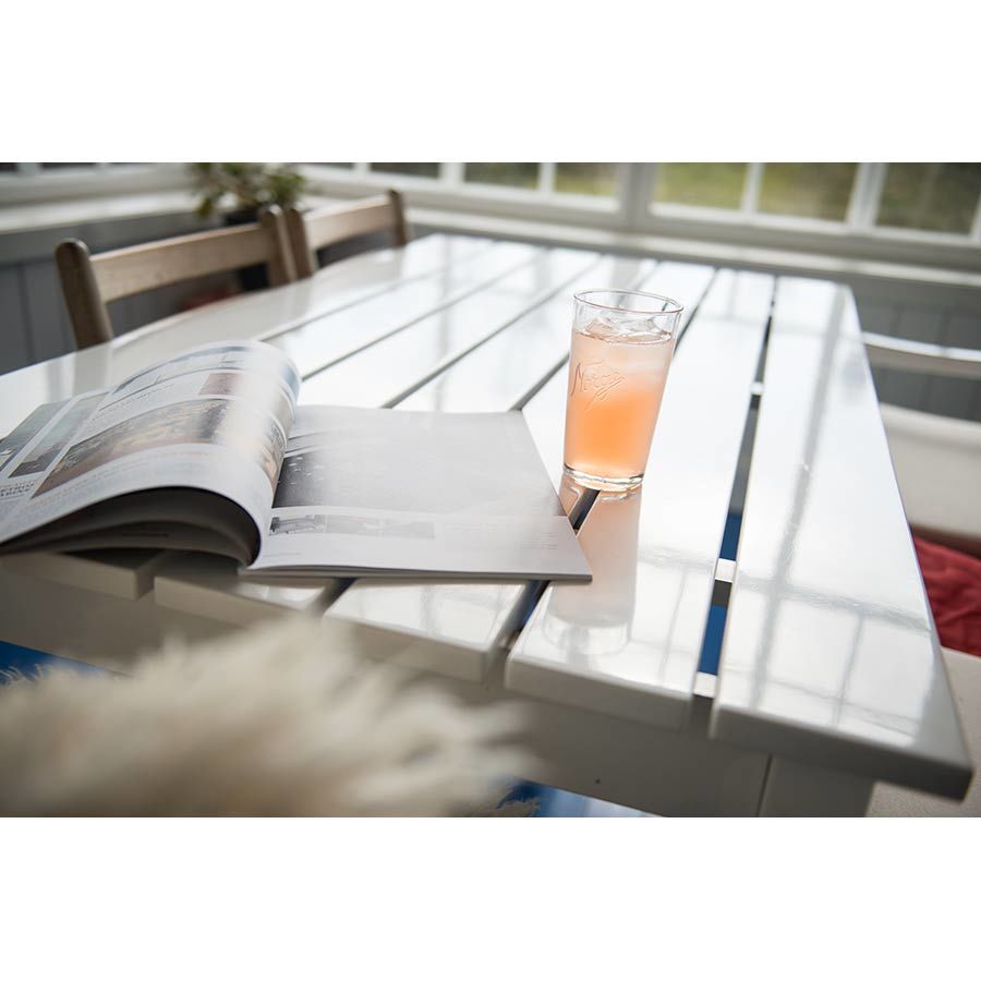 Norgesglasset drikkeglass 400ml med et glass fylt med en lesestoff på et moderne bord, perfekt for avslapning.