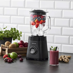 Nordic Sense blender i bruk med ferske bær og isbiter, og en smoothie ferdig på bordet.