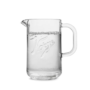 Norgesglasset glassmugge 1,2L fylt med klart vann, praktisk for hverdagsbruk.