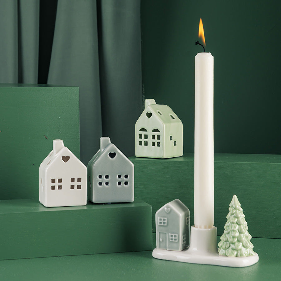 Porsgrunds Porselænsfabrik lysestake med flere hus og en stor lysestake, skaper hyggelig julekultur.