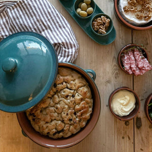 Terapottform Terra fra Porsgrunds Porselænsfabrik med lokk, fylt med bakst, anrettet på et tapasbord med tilbehør.