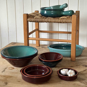 Ulike boller fra Porsgrunds Porselænsfabrik Terra-serien, inkludert serveringsbolle 38cm Verde, arrangert på et trebord.