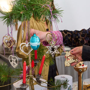 Julepynt inkludert forgylte og fargerike ornamenter på et juletre, med den forgylte julebilen fra Rosendahl Karen Blixen som en del av dekorasjonen.