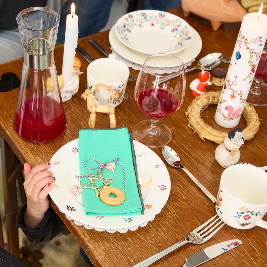 Festbord med julepynt, inkludert forgylt stjerne fra Rosendahl, glass med drikke og pyntede tallerkener.