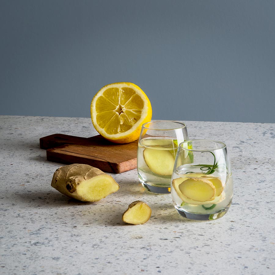 Hadeland Glassverk Odyssé shotglass 6cl på et bord med ingefær og sitron, som viser bruksområder og stil.