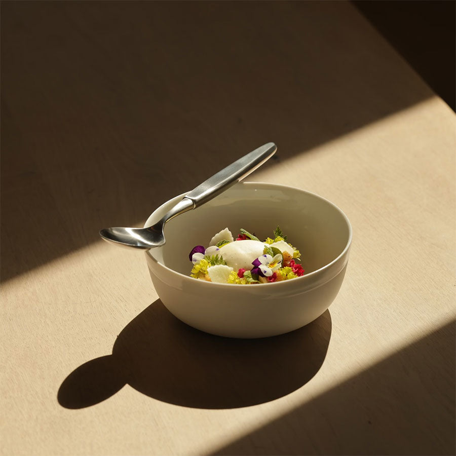 En skål med dessert og en Skaugum bestikksett skje i børstet stål. Viser hvordan bestikksettet kan brukes til elegante anledninger.