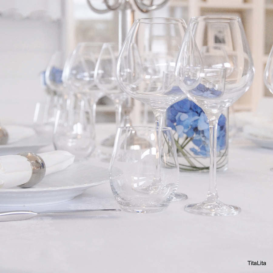 Elegant dekket bord med vannglass og vinglass fra HADELAND GLASSVERK, skaper en stilfull atmosfære.