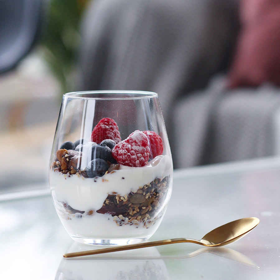 Vannglass fra HADELAND GLASSVERK fylt med yoghurt, granola og bær, ideelt for servering av desserter.