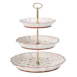 Villeroy & Boch Toys Delight etasjefat med tre nivåer, dekorert med nostalgiske julemotiver og gullfarget stativ, perfekt for servering av julekaker.