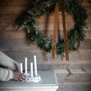 Wik & Walsøe Julemorgen Story adventsstake med lys, plassert på et bord med juledekorasjoner i bakgrunnen.