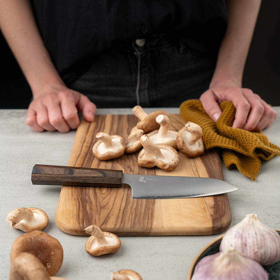 Yaxell Hana Santokukniv 12,5cm med ergonomisk pakkawood-håndtak og trelags konstruksjon, ideell for kutting av urter, grønnsaker og frukt.