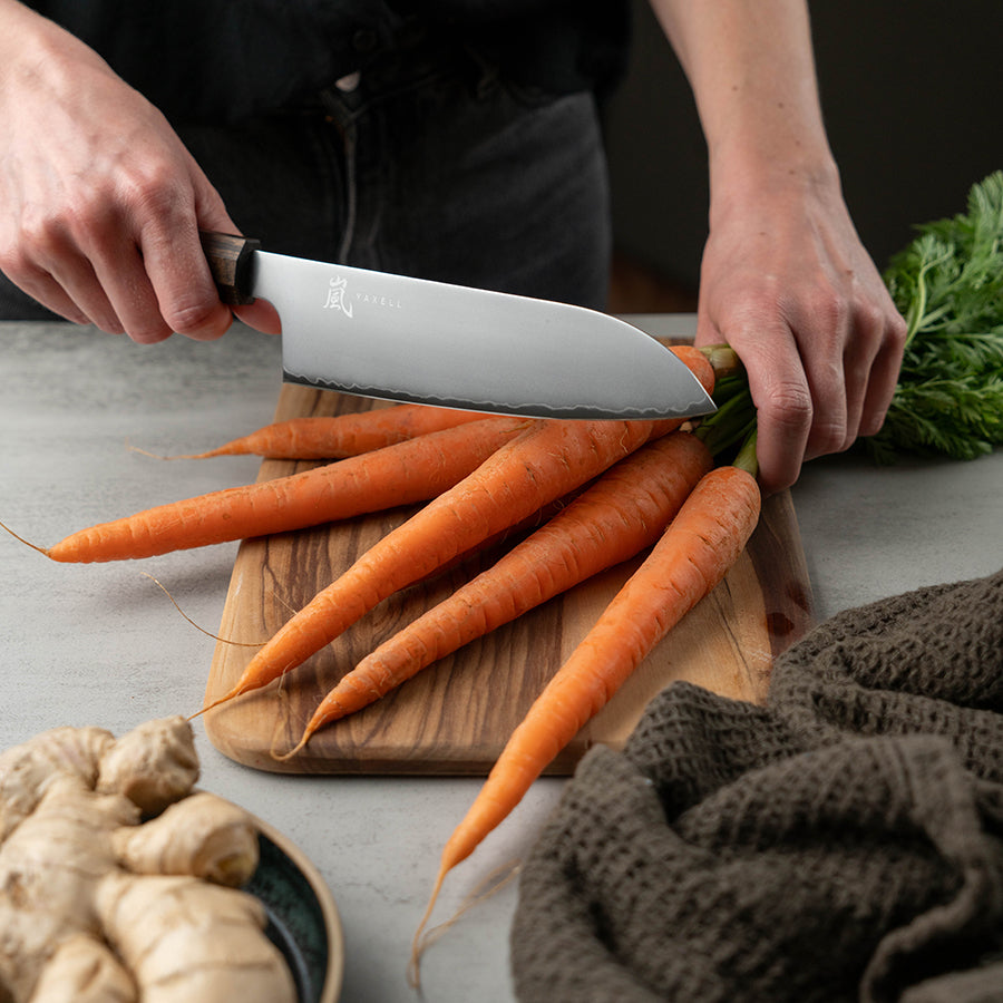 Yaxell Hana Santokukniv 16,5cm i bruk, perfekt til kutting av grønnsaker, fisk og kjøtt med japansk design.