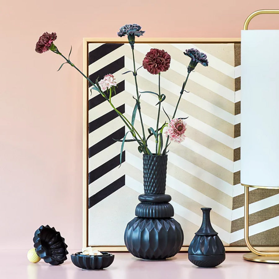 Dottir Nordic Design vaser med elegante former og teksturer, dekorert med blomster, på en stilren bakgrunn. Disse unike vaser fra Dottir viser håndverk og kunstnerisk design, perfekt for moderne interiør.