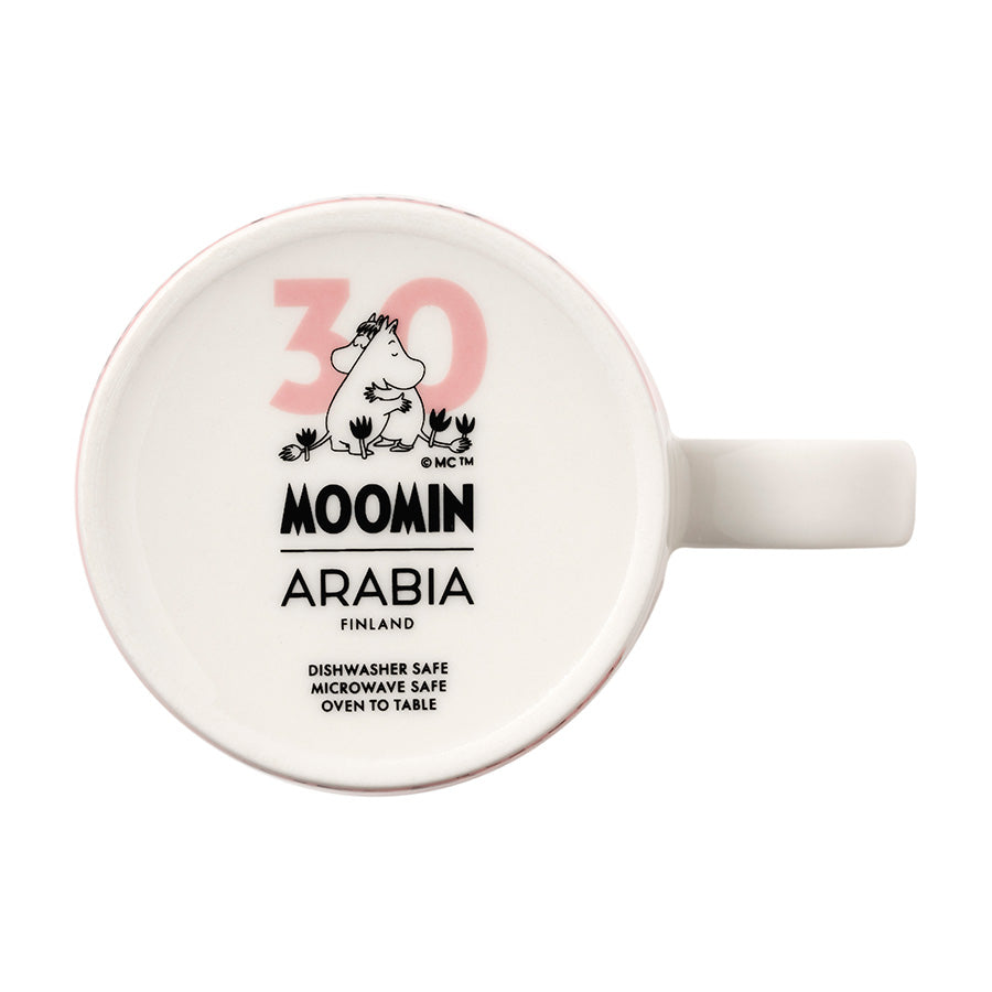 Bunnvisning av mummikopp fra Moomin Arabia med jubileumslogo, inkluderer informasjon om at den er oppvaskmaskin- og mikrobølgeovnsikker.