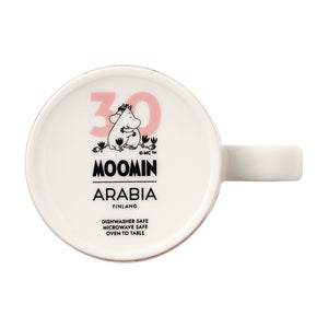 Bunnvisning av mummikopp fra Moomin Arabia med jubileumslogo, inkluderer informasjon om at den er oppvaskmaskin- og mikrobølgeovnsikker.