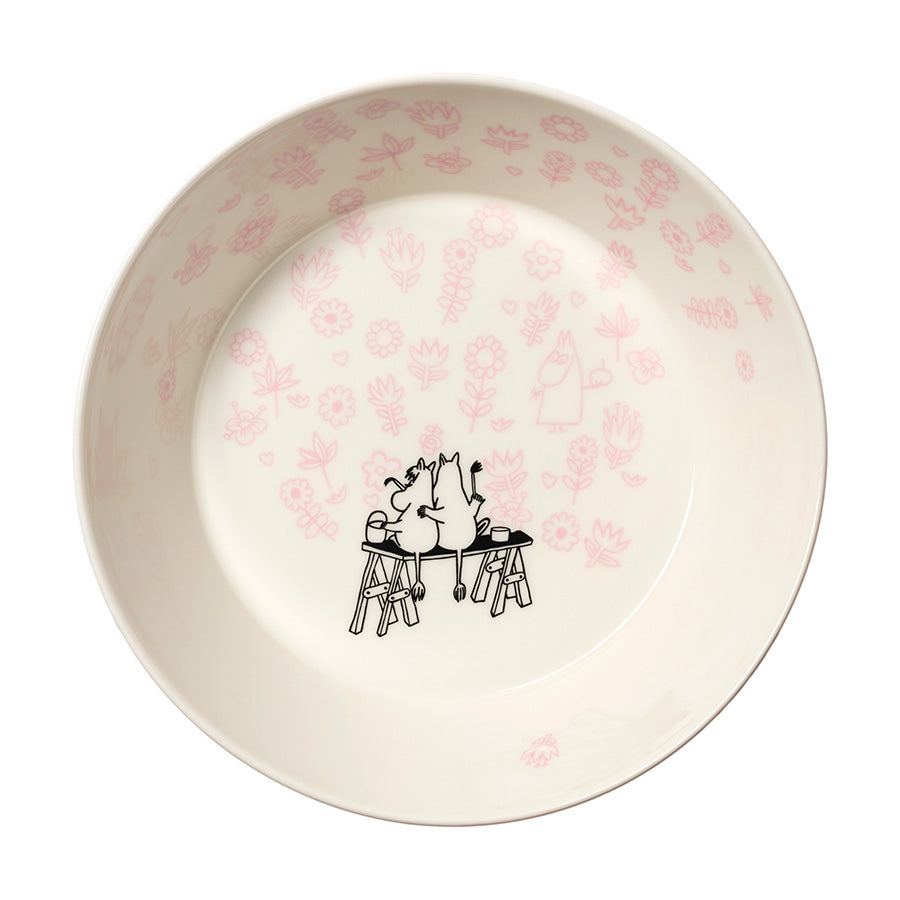 Innvendig av Moomin Arabia serveringsskål med rosa blomstermotiv og Mumi-figurer som koser seg ved bordet.