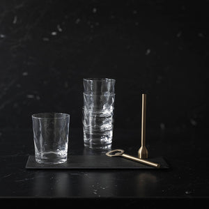 Vannglass stablet pent på en svart skiferplanke, fremhever deres stilige karakter.
