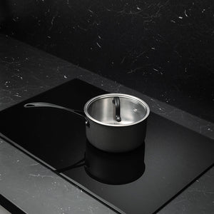 Elegant gryte fra grytesettet som står alene på en svart koketopp, med fokus på det holdbare materialet og den stilige utformingen.