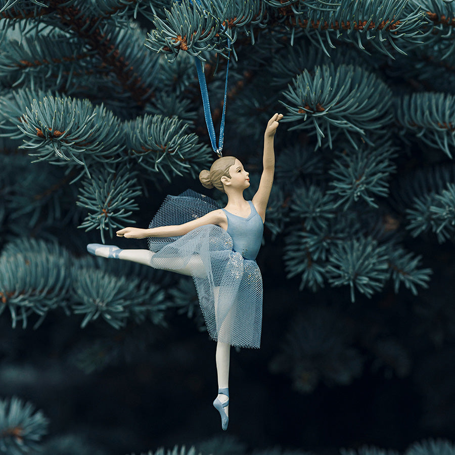 Ballerinafigur i dansende positur fra PORSGRUNDS PORSELÆNSFABRIK, PP Jul Fifth Jump Hengepynt 12,5cm, hengende på juletre med lyseblått bånd.