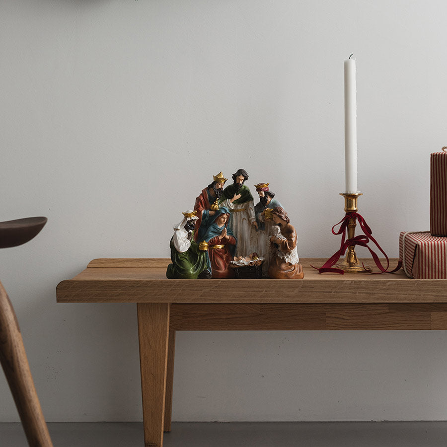 Christiania 1739 Julekolleksjon Julekrybbe 31x25cm. Julekrybben plassert på et bord med juledekorasjoner, inkludert lys og gaver.