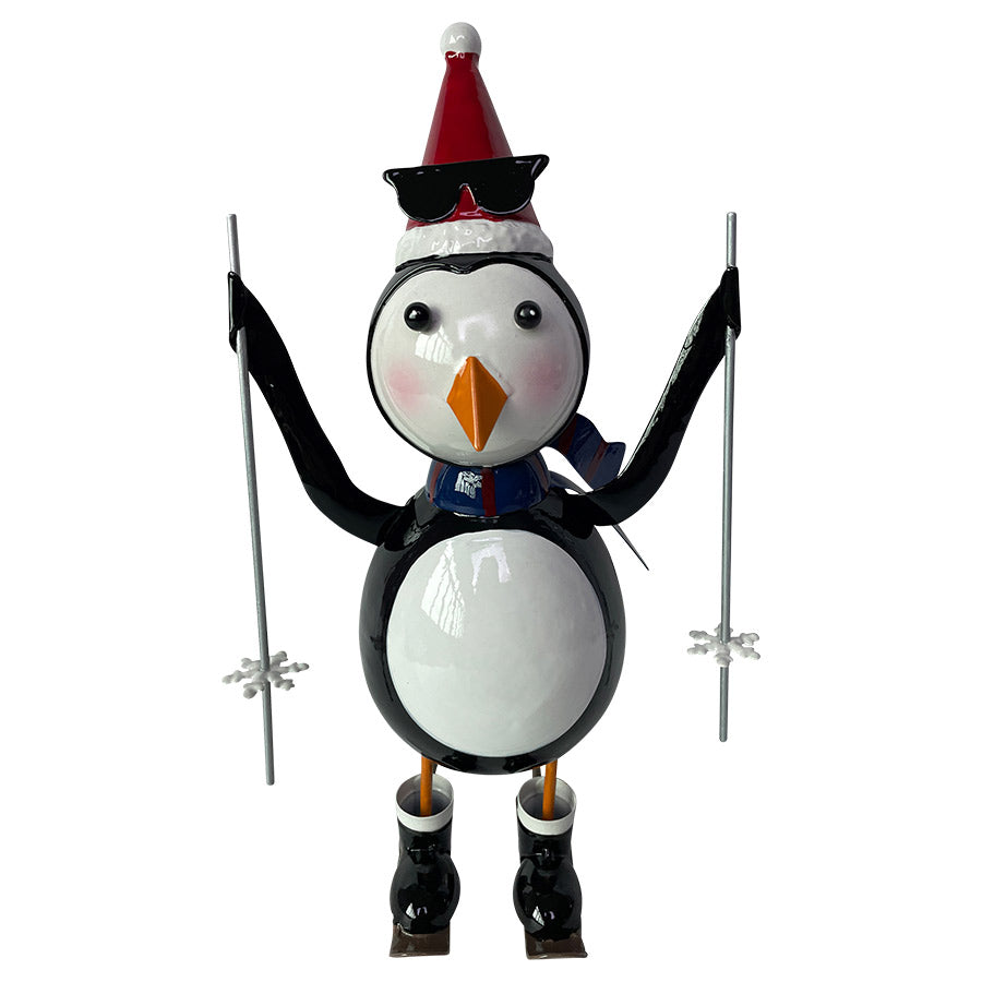 Christiania 1739 Julekolleksjon Figur Pingvin På Ski 30cm. En fargerik pingvin iført solbriller og julenissehatt, står med ski og smil om munnen.