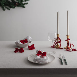 Utsikt over julebord med Christiania 1739 serviettringer i rød sløyfe, som tilfører varme og tradisjon til festligheten.