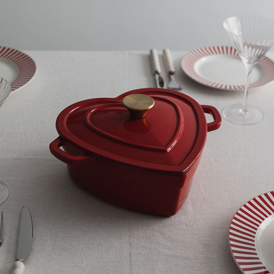 Christiania 1739 Julekolleksjon Støpejerngryte Hjerte 2.8l Rød plassert på et elegant dekket bord, klar for servering.