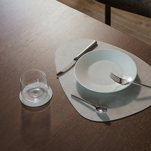 Grå Lago coaster og bordbrikke stylet med tallerken, bestikk og glass på spisebord
