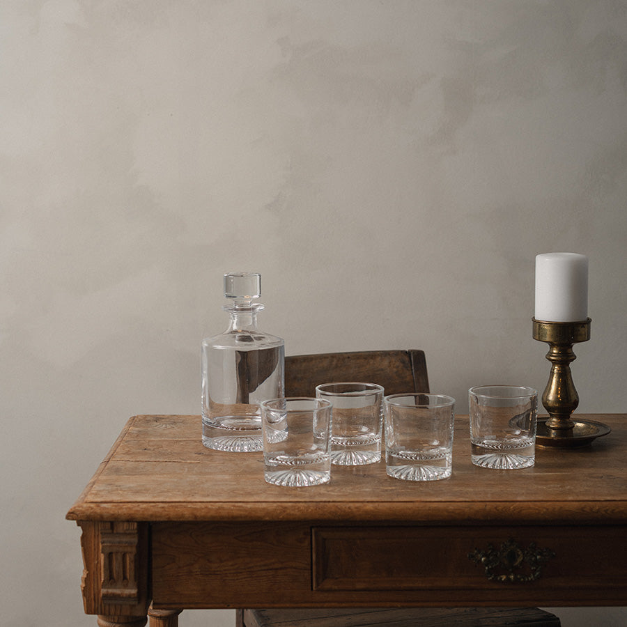 Sett med Christiania 1739 whiskeyglass og karafle på en trebord, illustrerer perfekt kombinasjonen av eleganse og funksjonalitet.