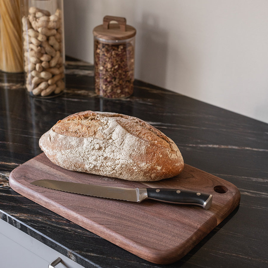 ClassicPro brødkniv plassert ved siden av et ferskt brød på et moderne kjøkken.