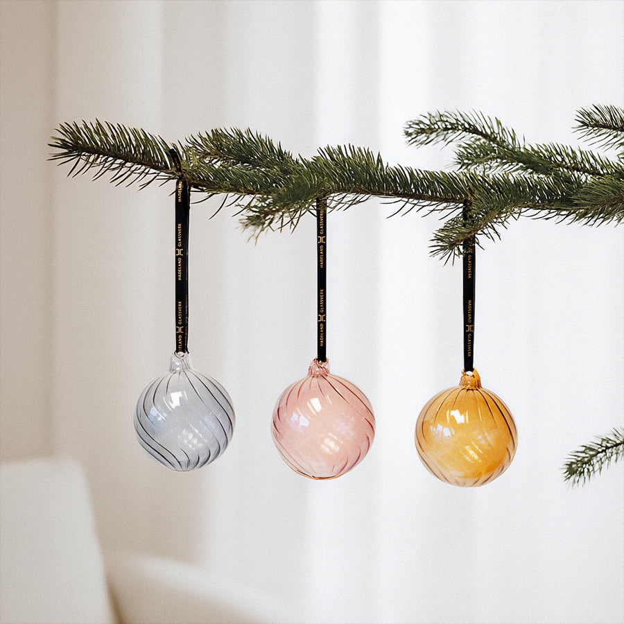 Glasskuleklang julekuler henger på en juletregren, med fargene sølv, rosé og gyllen, som gir et stilfullt juletreutseende.